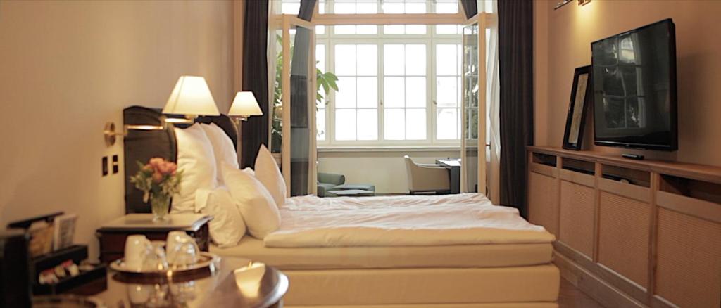 una camera d'albergo con un letto e un grande specchio di Hotel Hollerbusch a Weimar