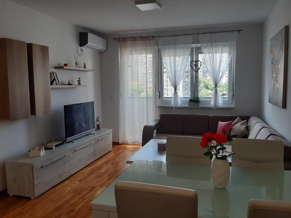 een woonkamer met een bank en een tafel bij Elena apartmani in Tuzla