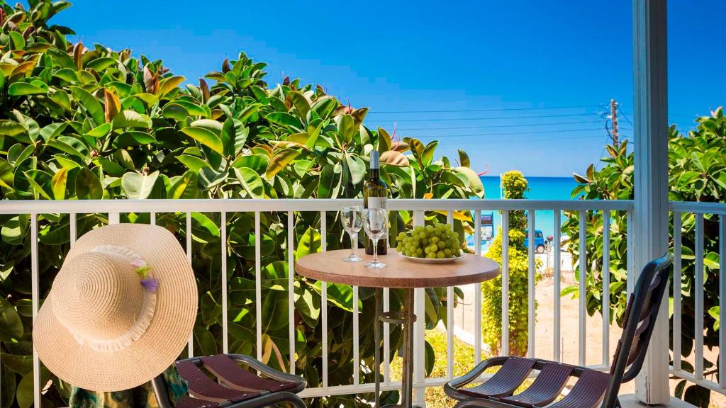 a table and chairs on a balcony with a view of the ocean at Beachfront Suites Lourdas in Lourdata
