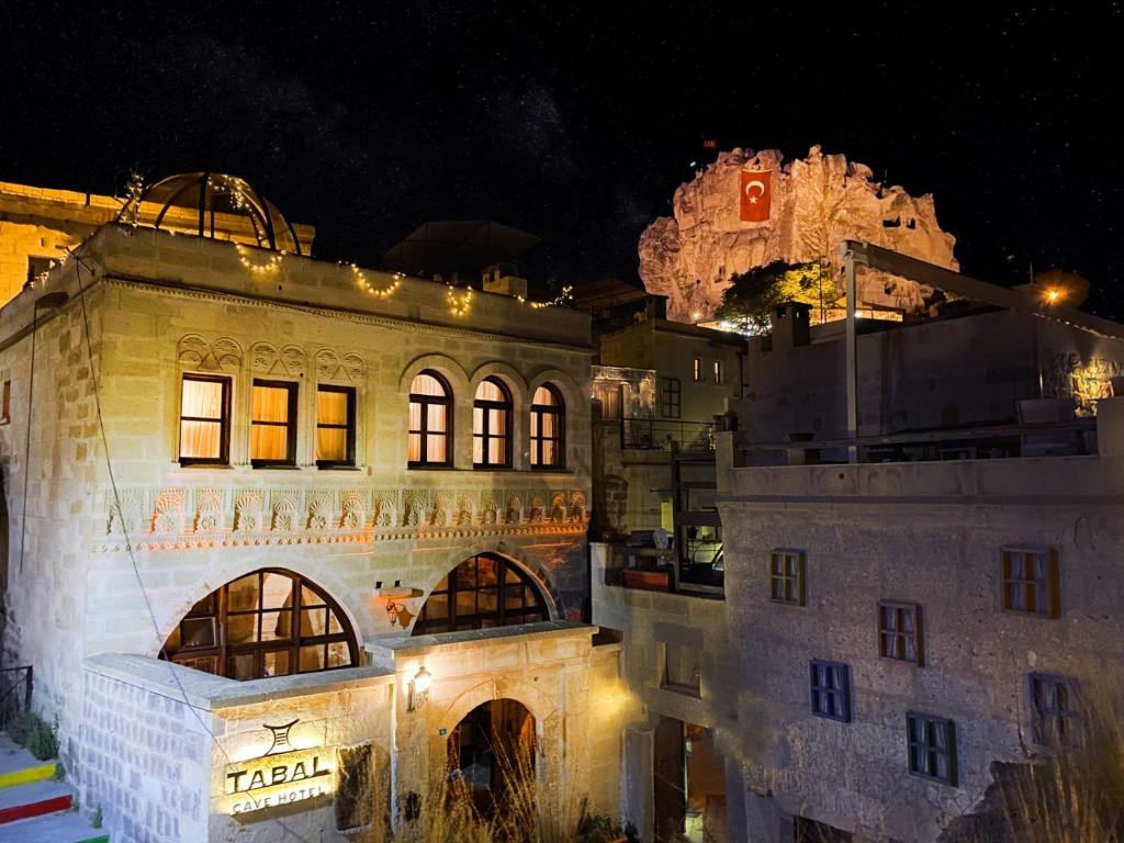 um edifício com luzes acesas à noite em Tabal Cave Hotel em Üçhisar
