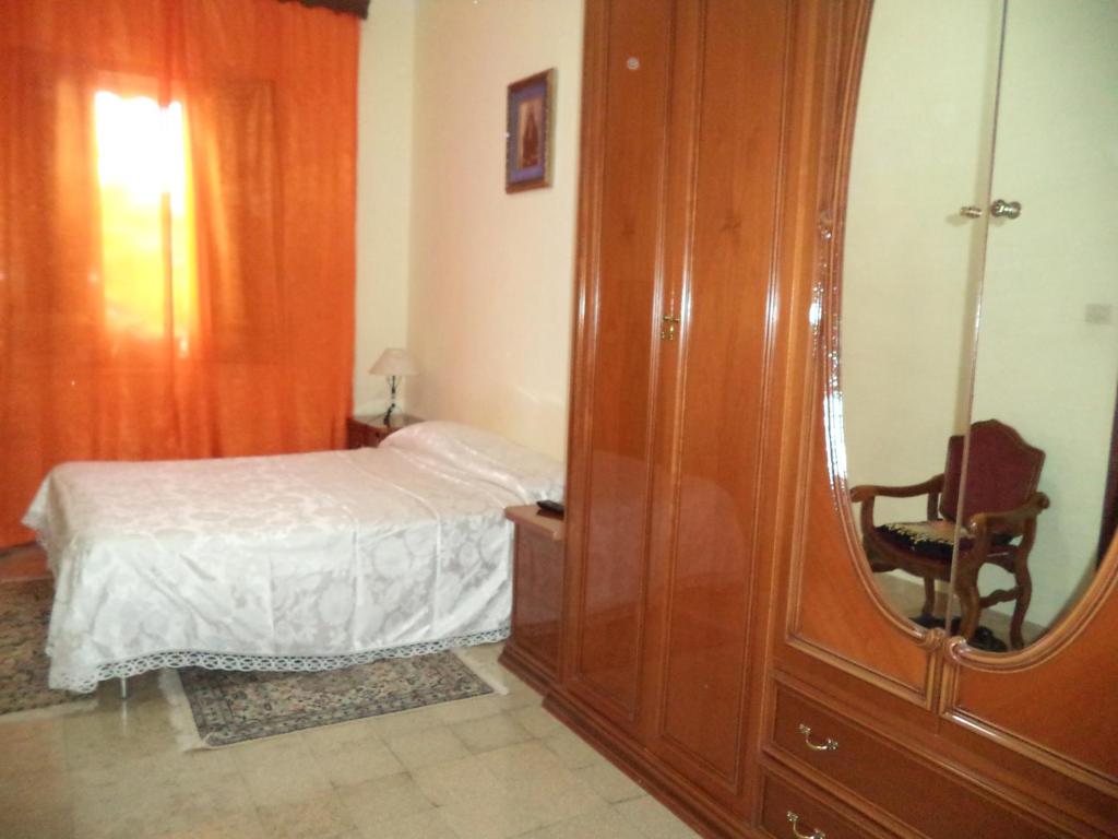 una camera con letto, cassettiera e specchio di Il Gelsomino a Custonaci