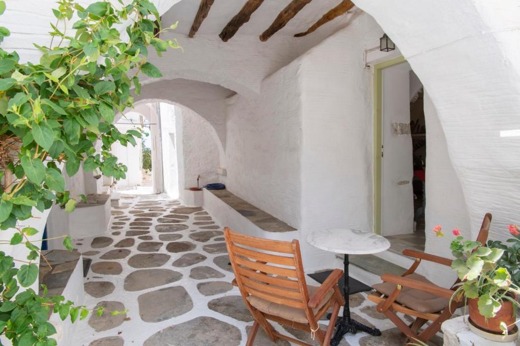 a room with a stone floor and a table and chairs at Traditional stonebuilt house in Kampos Paros