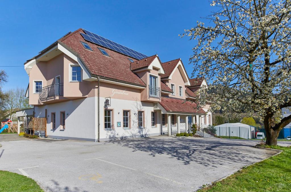 ein großes Haus mit einer Einfahrt davor in der Unterkunft Hotel Delalut in Ravne na Koroškem