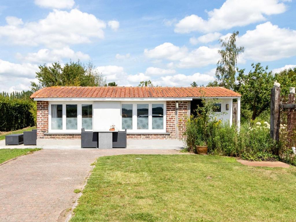 a small brick house with a red roof at Cozy Chalet with Private Garden near Lake in Westouter in Reningelst