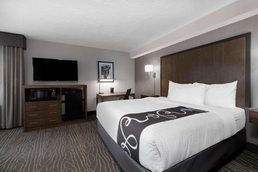 a hotel room with a bed and a flat screen tv at La Quinta by Wyndham Anchorage Airport in Anchorage