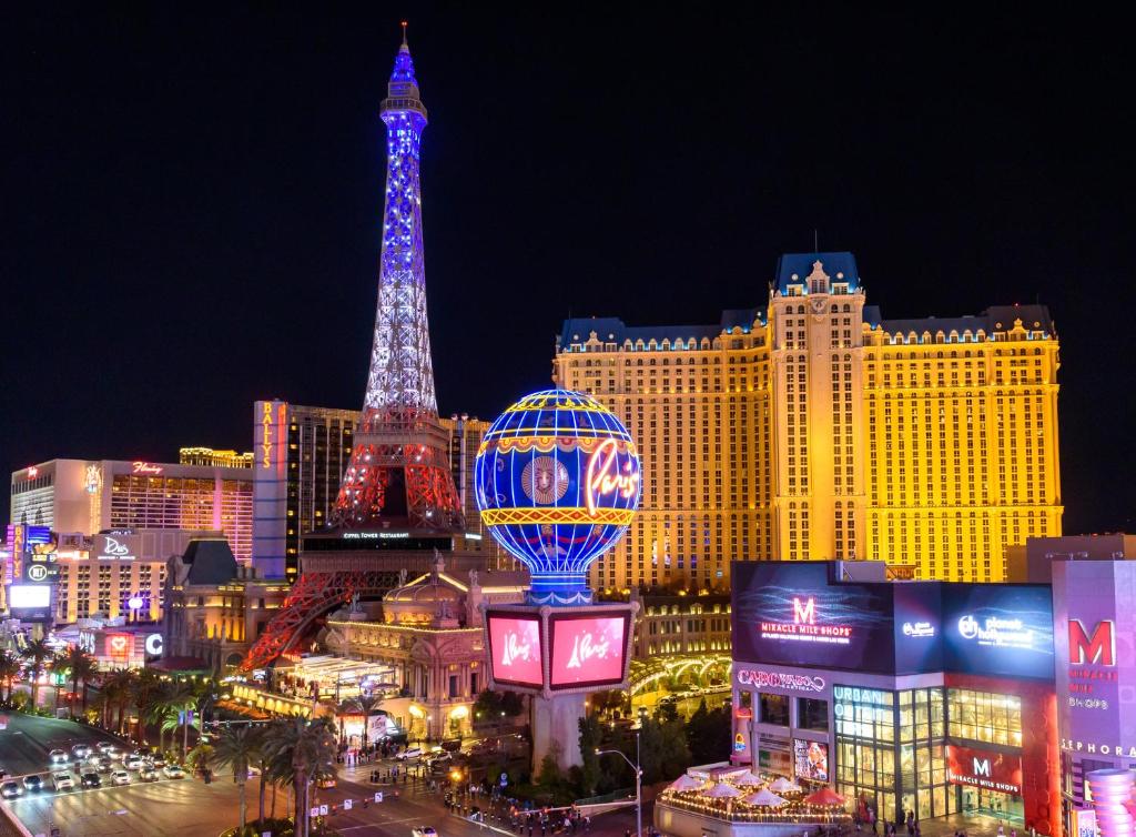a city with the eiffel tower lit up at night at Paris Las Vegas Hotel & Casino in Las Vegas