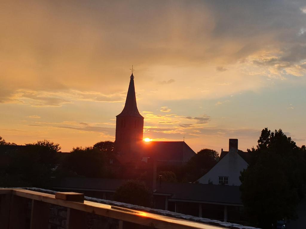 a church steeple with the sunset in the background at Singel 9 in Domburg