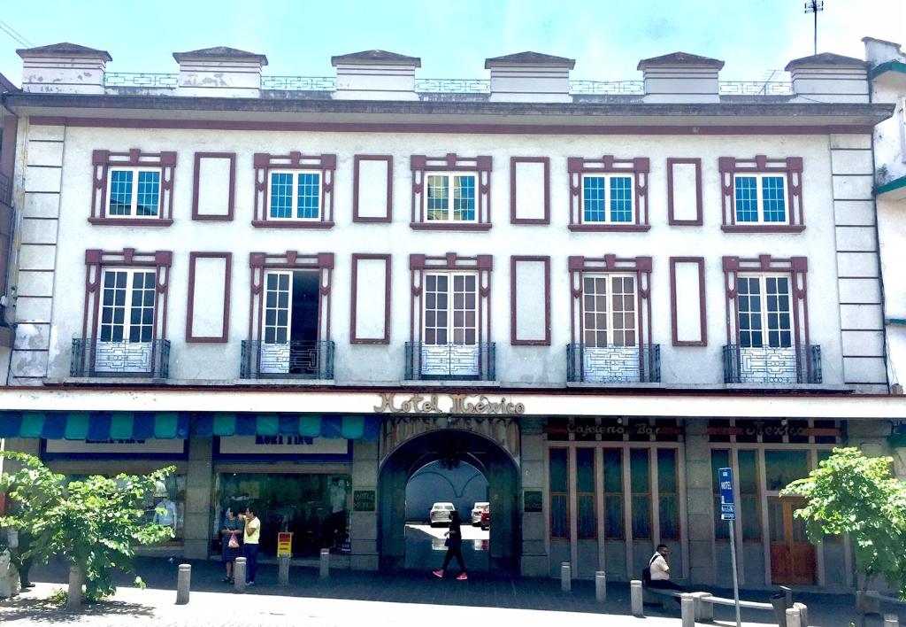 a large white building with people walking in front of it at Hotel Mexico in Xalapa