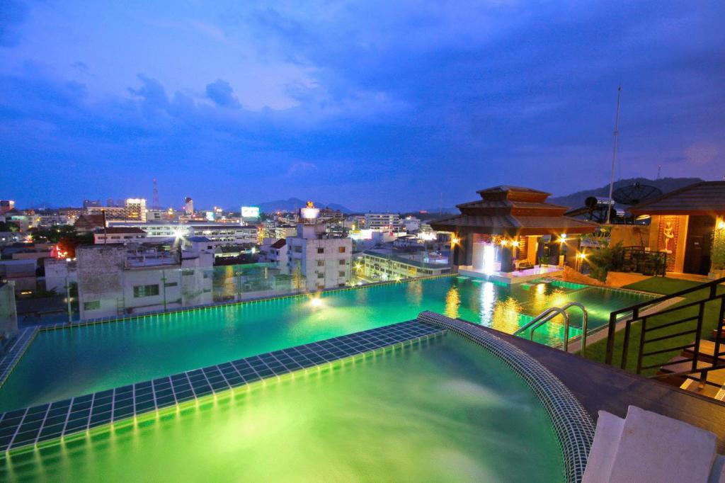 een zwembad op de top van een gebouw 's nachts bij Chalelarn Hotel Hua Hin in Hua Hin
