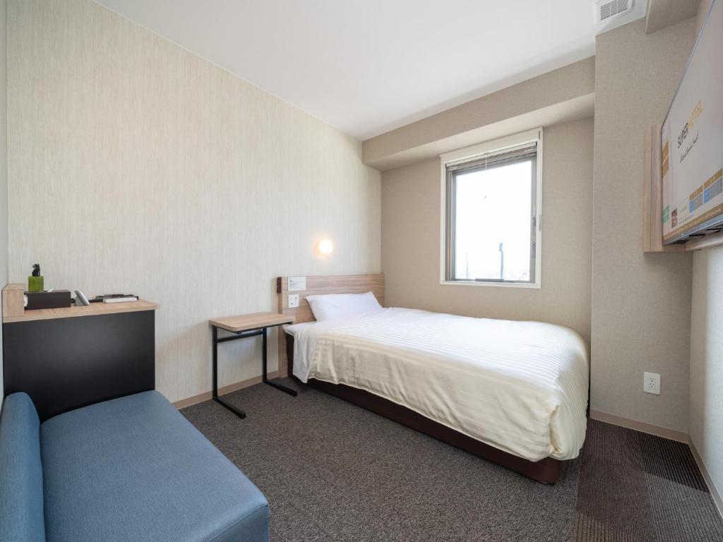 Postel nebo postele na pokoji v ubytování Super Hotel Iyo Saijo