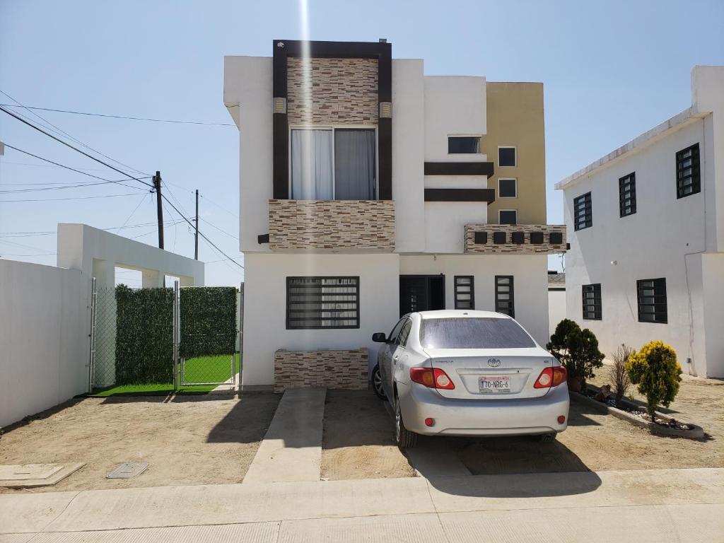 un coche aparcado en un estacionamiento frente a una casa en Casa cerca de Estero Beach, en Ensenada