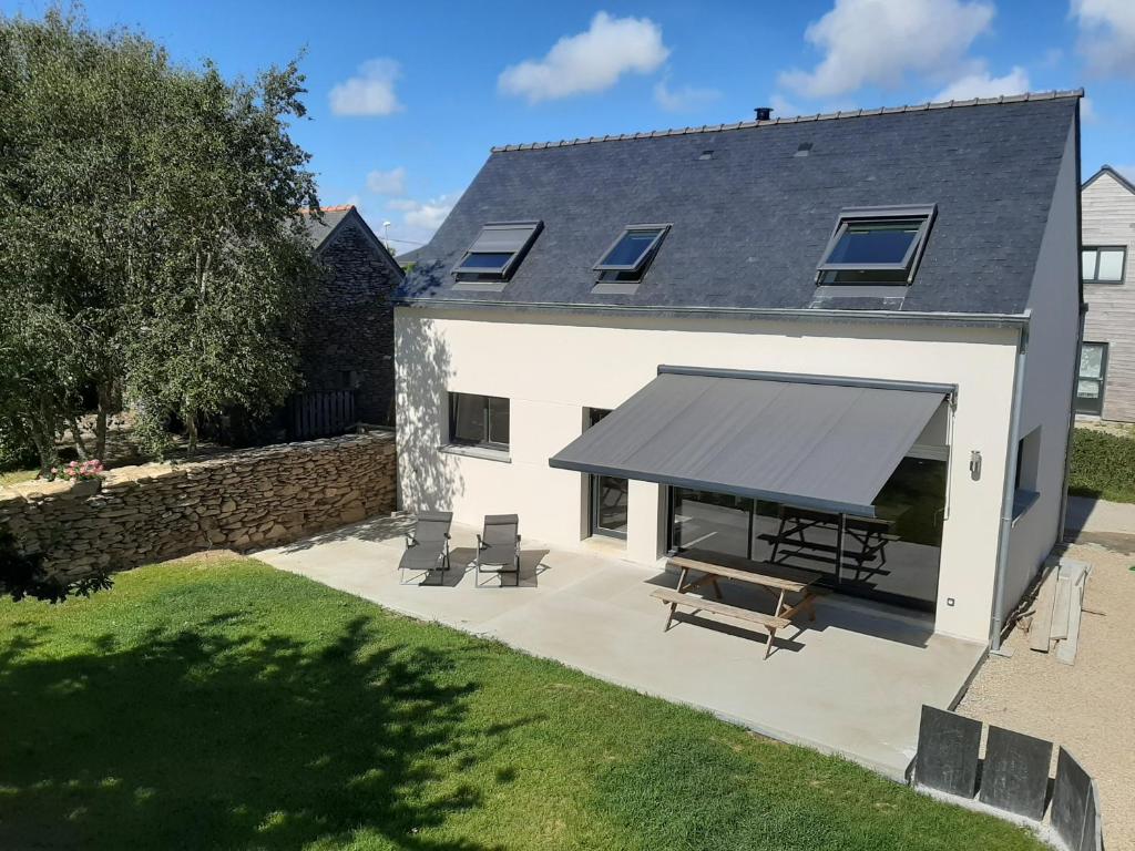 una casa blanca con un toldo negro en ella en la maison des lavandières en Le Conquet