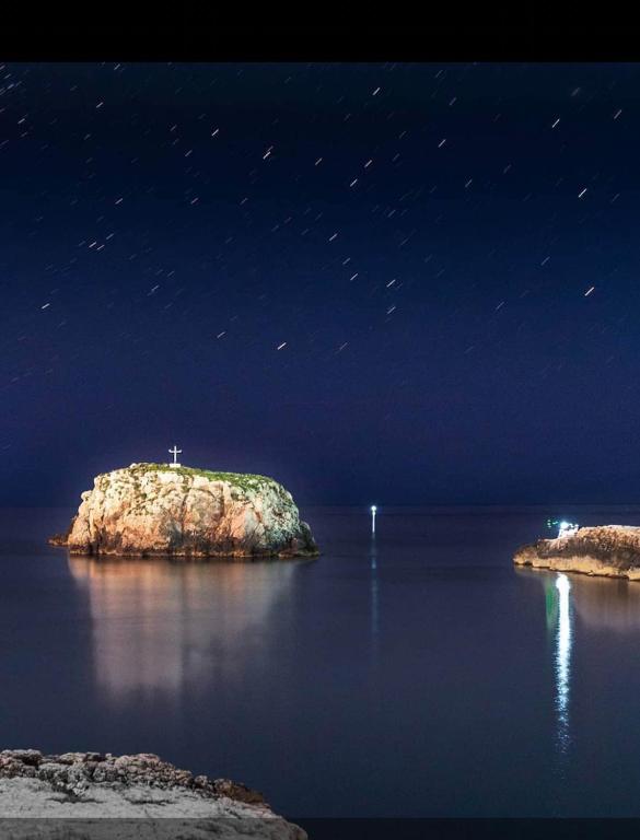 a small island in the middle of the water at night at Ville Alba & Azzurra in Polignano a Mare