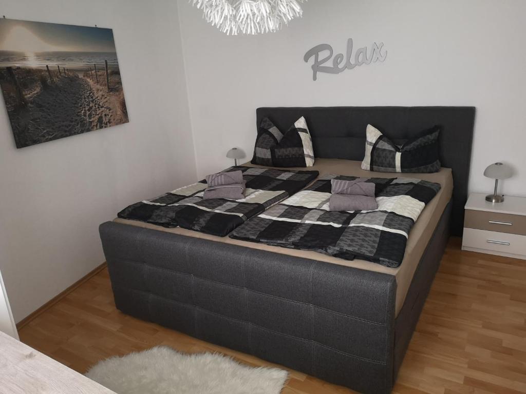 ein großes Bett in einem Schlafzimmer mit einer schwarzen und weißen Decke in der Unterkunft Ferienwohnung Würzburg/Heidingsfeld in Würzburg