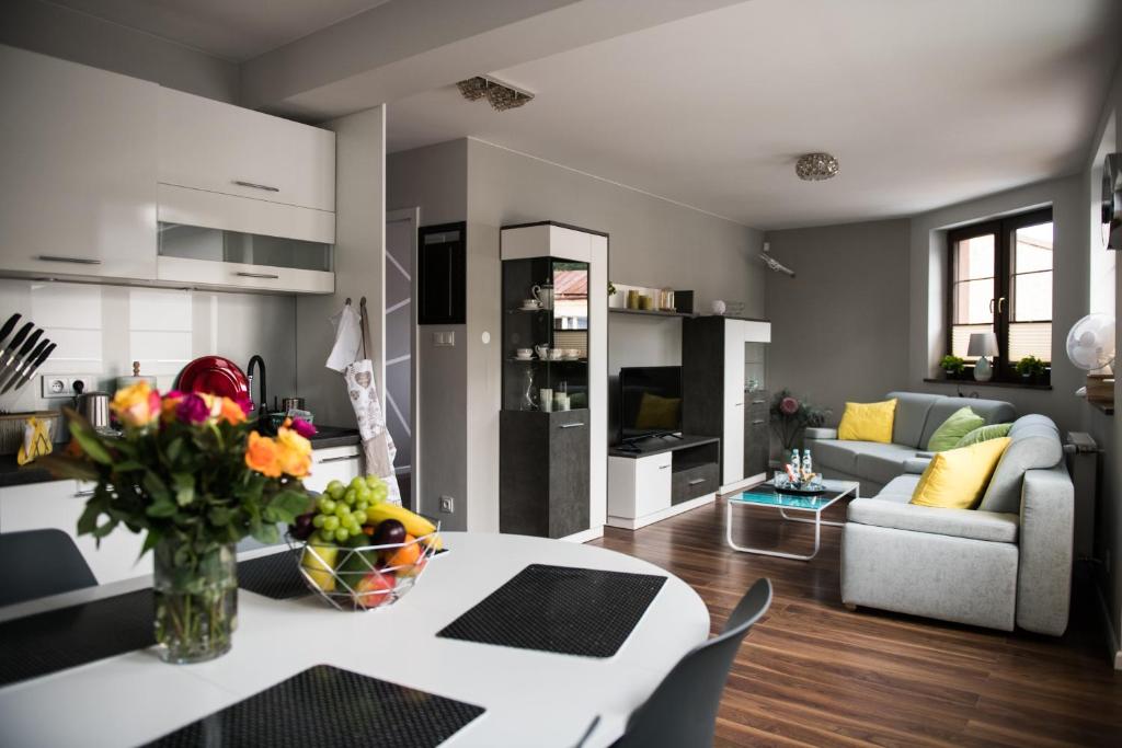 a kitchen and living room with a table and a couch at Apartamenty Królewskie in Chęciny