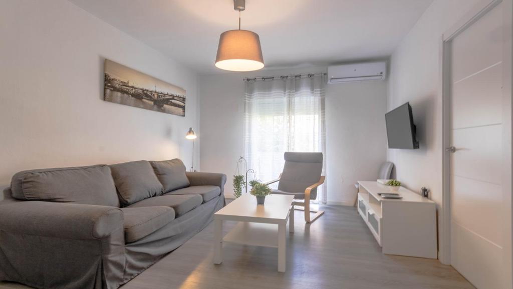 ein Wohnzimmer mit einem Sofa und einem Tisch in der Unterkunft Apartamento Santa Justa in Sevilla