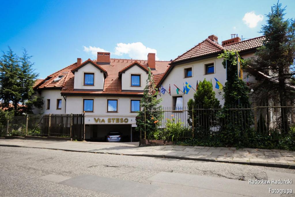 a white house with a fence in front of it at Pokoje Gościnne Via Steso in Gdańsk