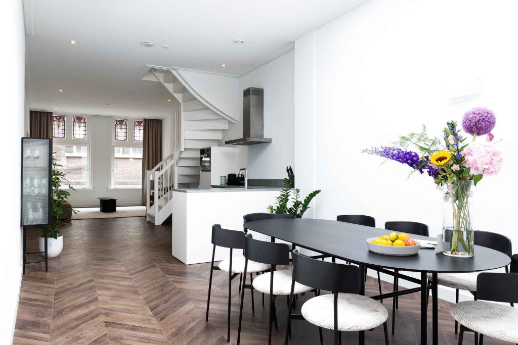 Anegang Boutique Appartement في هارلم: مطبخ وغرفة طعام مع طاولة وكراسي