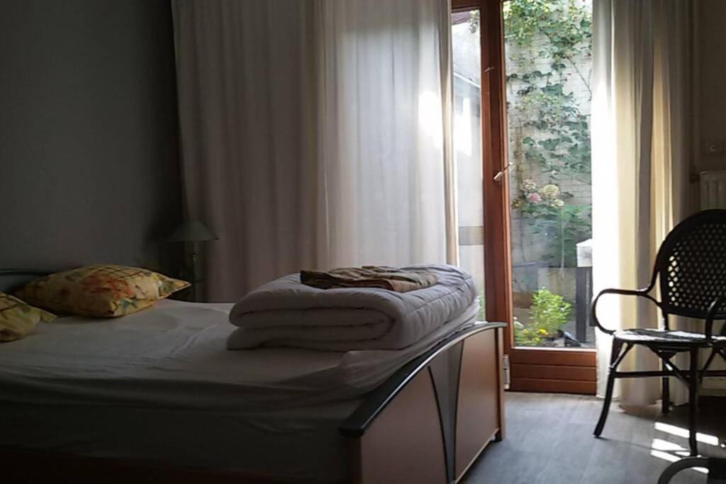 een bed met handdoeken in een kamer met een raam bij Stadswoning Roermond in Roermond