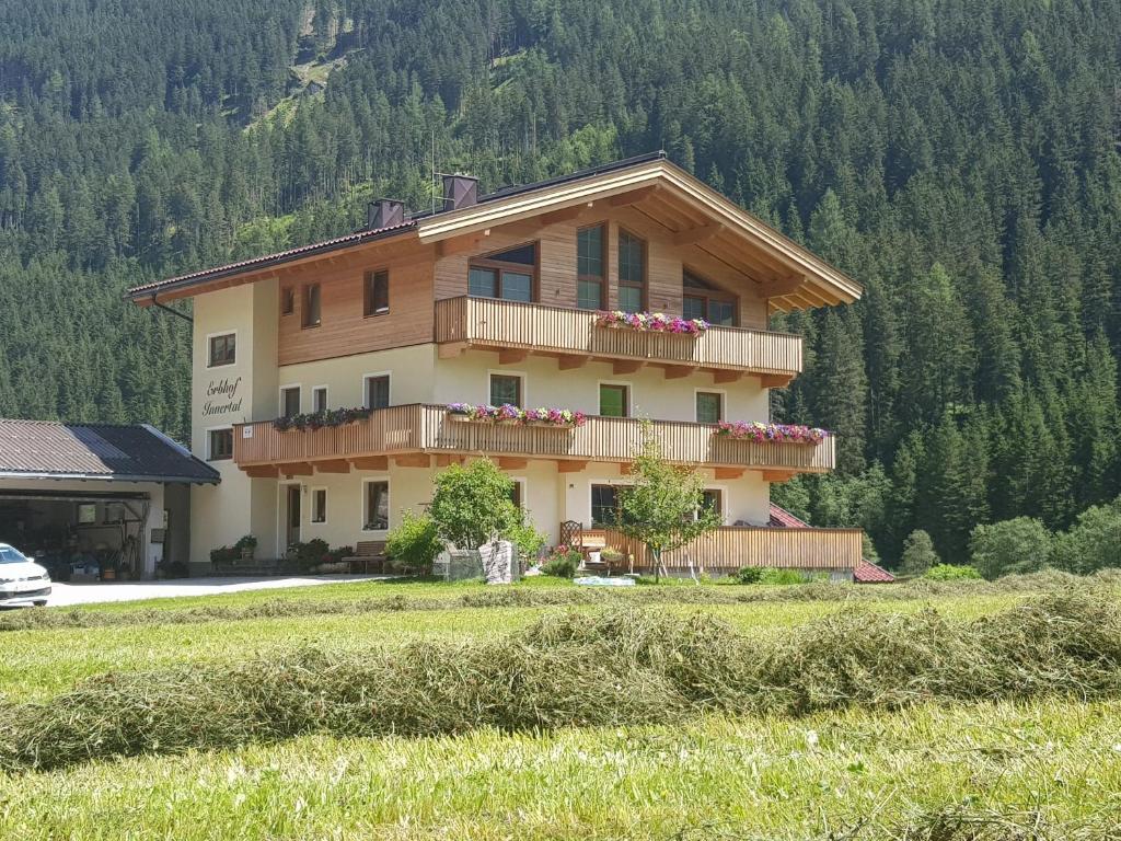 a house with flowers on the balconies on a hill at Erbhof Innertal in Tux