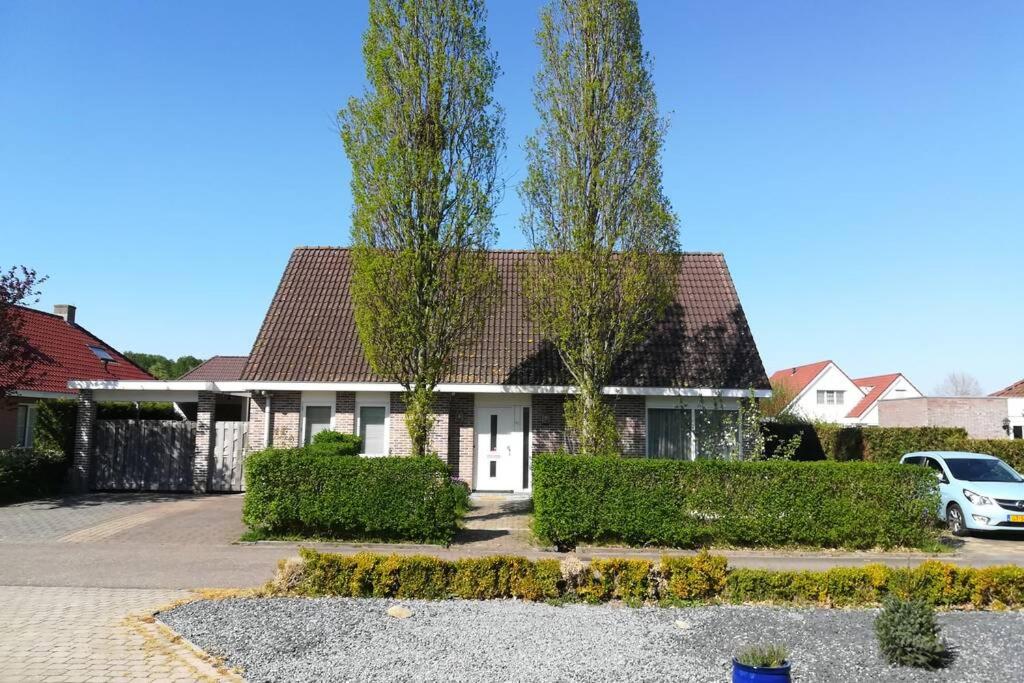 a house with two trees in a driveway at Vakantiehuis Horsterwold in Zeewolde