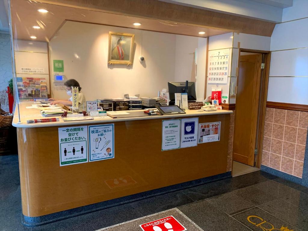 a counter in a restaurant with a person behind it at Crown Hotel Okinawa in Okinawa City