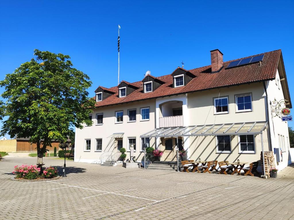 a large white building with a tree in front of it at Landgasthof Braun in Mindelstetten