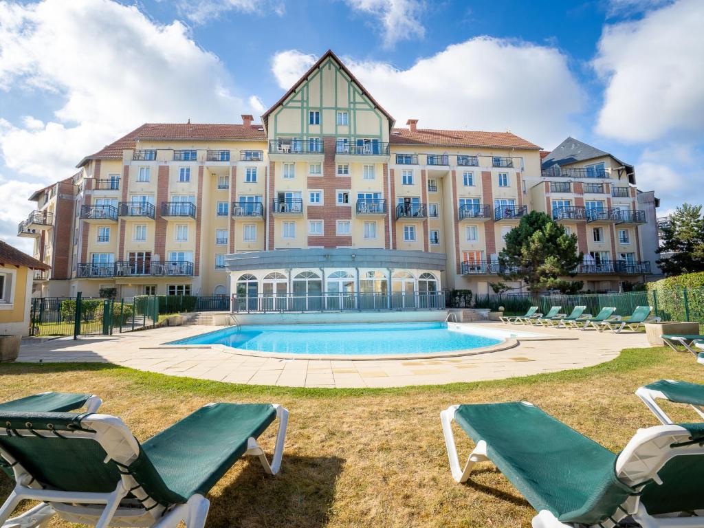 - un grand bâtiment avec une piscine et des chaises longues dans l'établissement Apartment Port Guillaume-6 by Interhome, à Cabourg