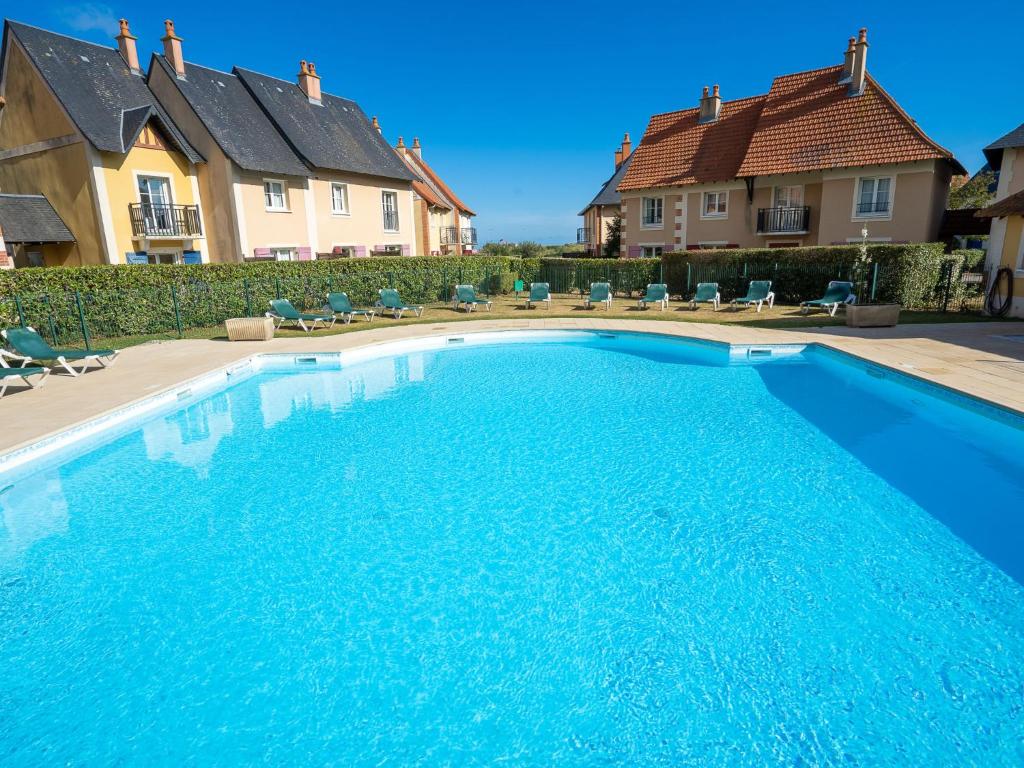 a large blue swimming pool in front of some houses at Apartment Port Guillaume-6 by Interhome in Cabourg