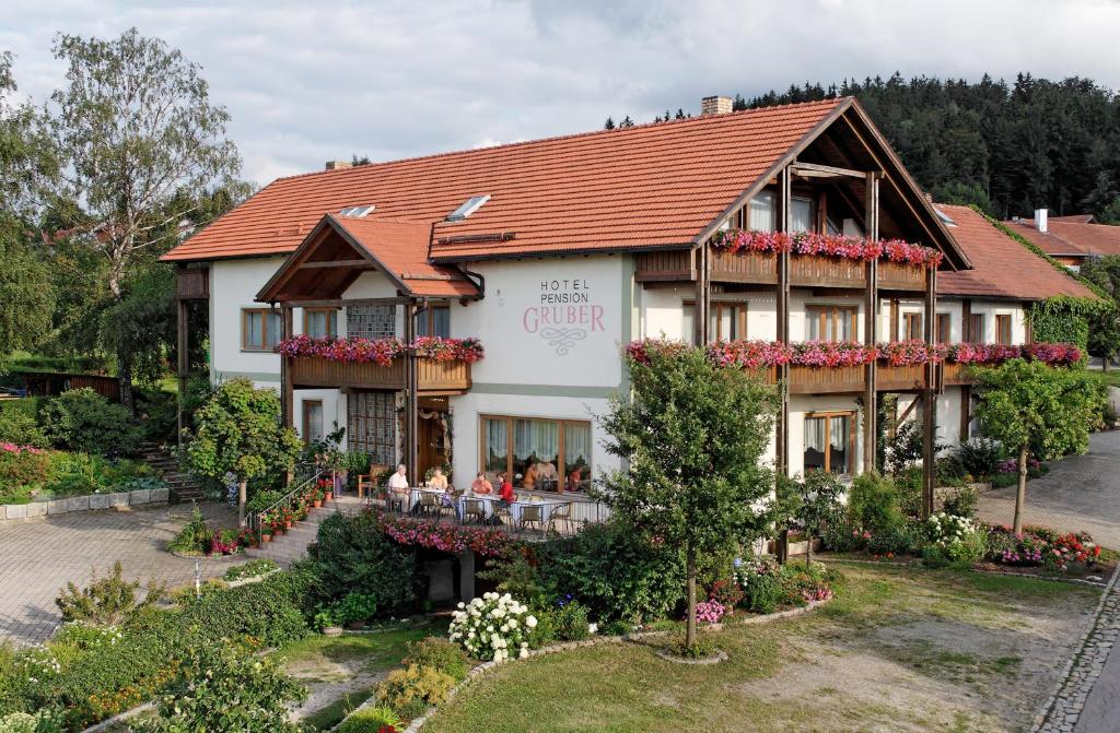 um edifício com pessoas sentadas fora dele em Landhotel Gruber em Waldmünchen