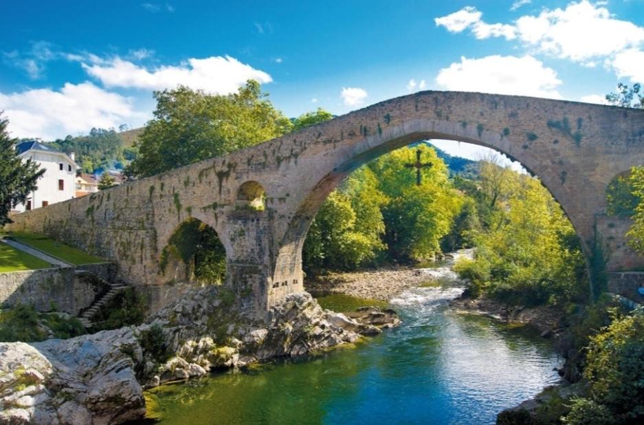 un vecchio ponte di pietra sopra un fiume di En el Sella a Cangas de Onís