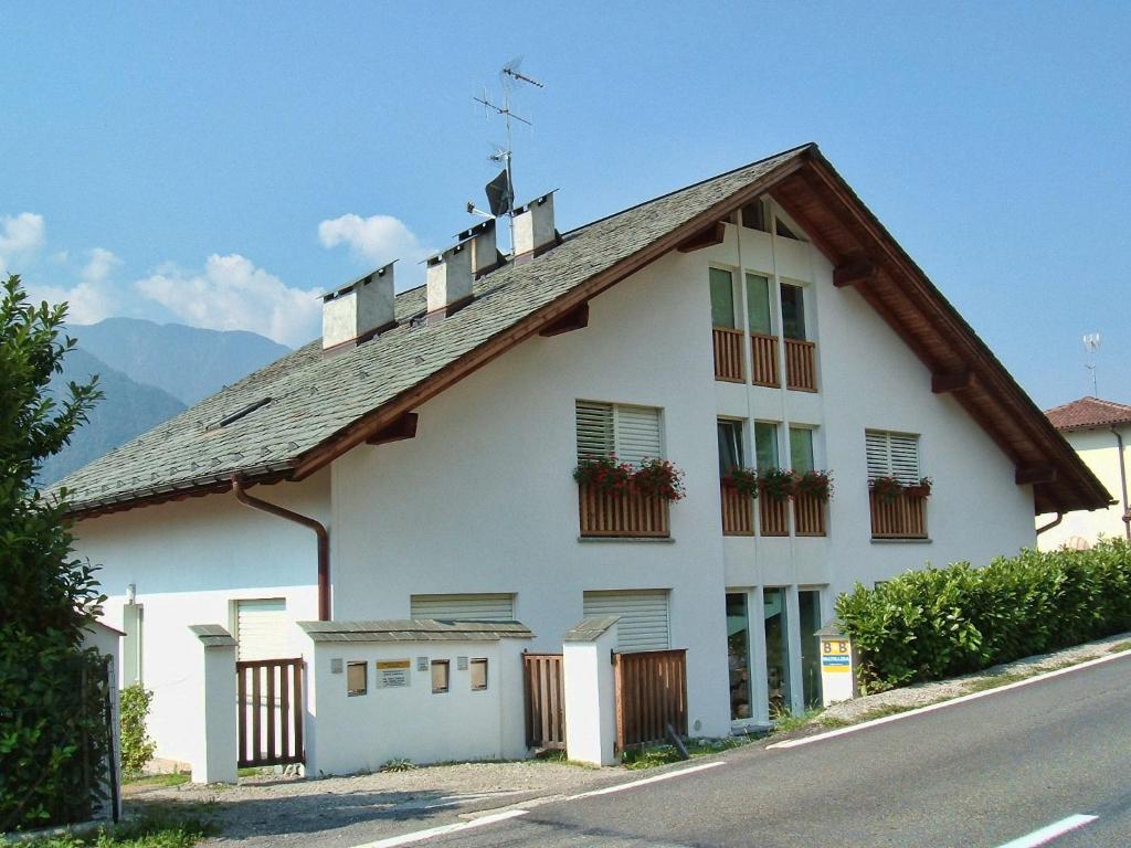 una casa blanca con techo de gambrel en Bed & Breakfast Valtellina, en Castione Andevenno