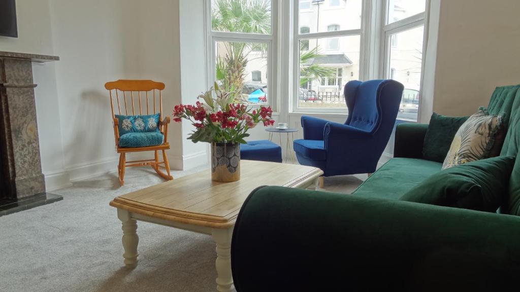 ein Wohnzimmer mit einem Sofa, einem Tisch und Stühlen in der Unterkunft Snowdon Retreat Villa by Seaside Llandudno in Llandudno