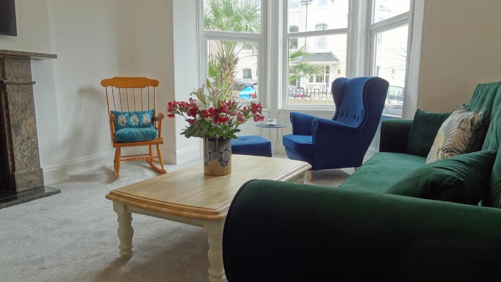 Una sala de estar con un sofá, una mesa y sillas. en Snowdon Retreat Villa by Seaside Llandudno, en Llandudno