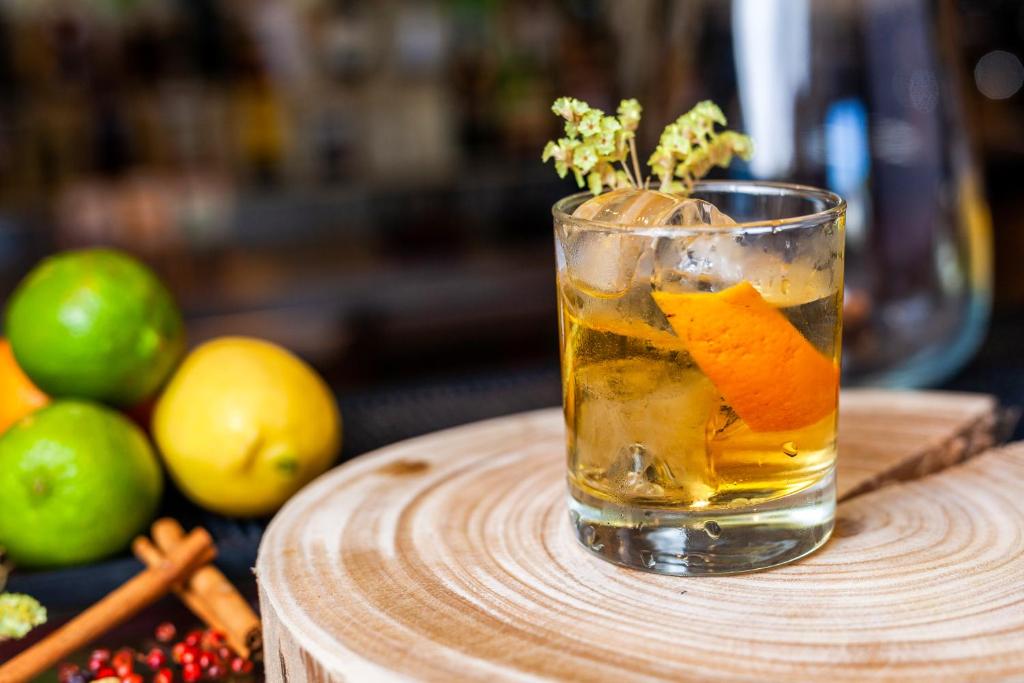 a drink on a wooden table with oranges and apples at Sea Porto Hotel in Matosinhos