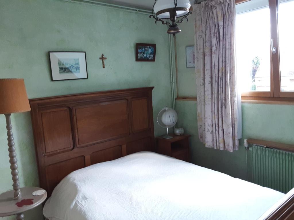 een slaapkamer met een bed en een kruis aan de muur bij B&BAcacias in Croix