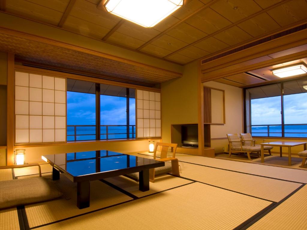 Habitación grande con mesa y algunas ventanas. en Kagaya, en Nanao