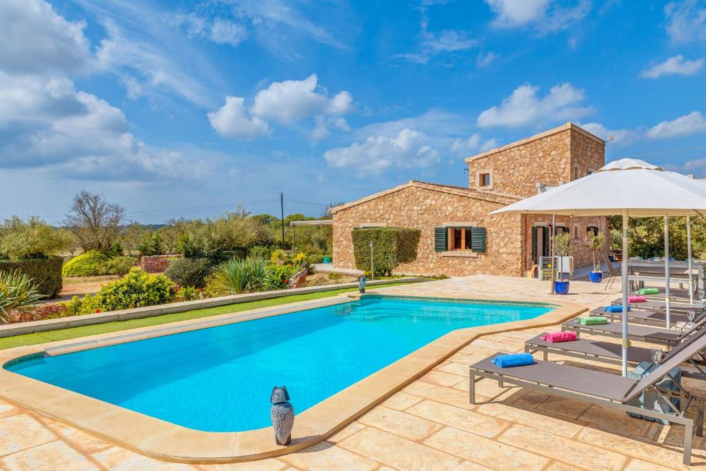 a villa with a swimming pool and patio furniture at Can Xesquet - Morell in Ses Salines