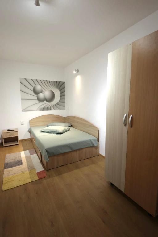 a bedroom with a bed and a cabinet in it at Garsoniera in Cluj-Napoca