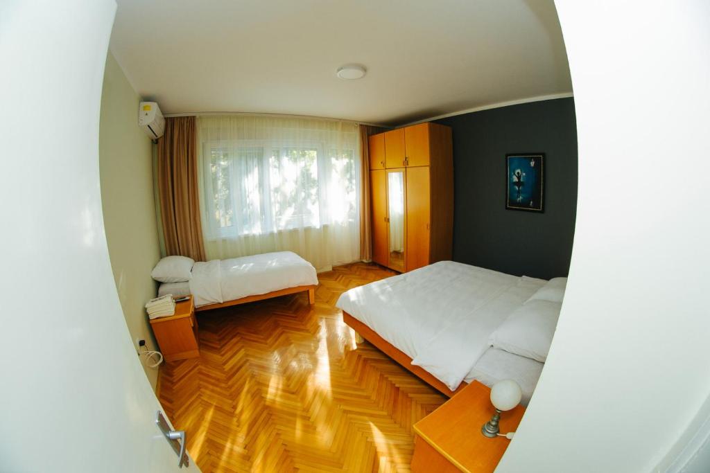 sypialnia z dużym łóżkiem i oknem w obiekcie Central w mieście Sombor