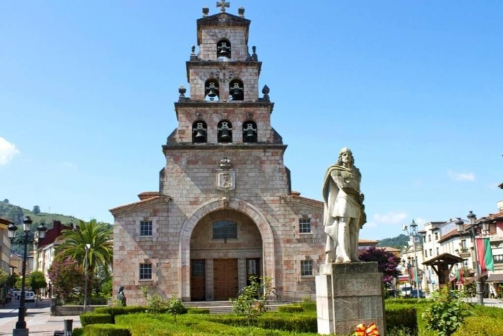 un edificio con una estatua delante en PLAZA CENTRAL CANGAS DE Onís, en Cangas de Onís