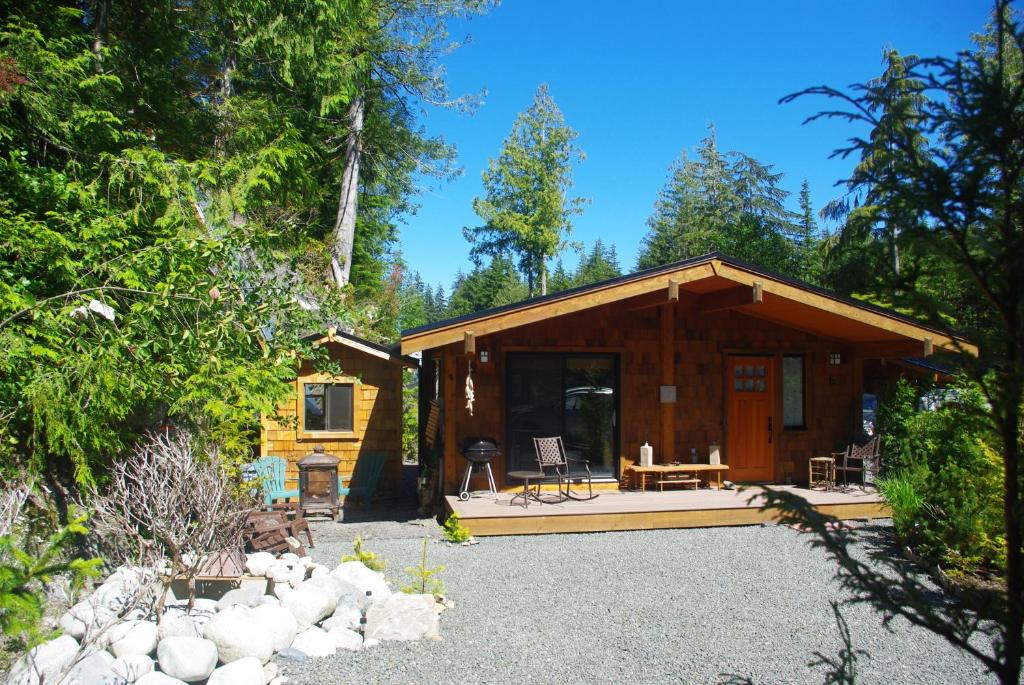 a log cabin in the woods with a patio at Wild Coast Chalets in Port Renfrew
