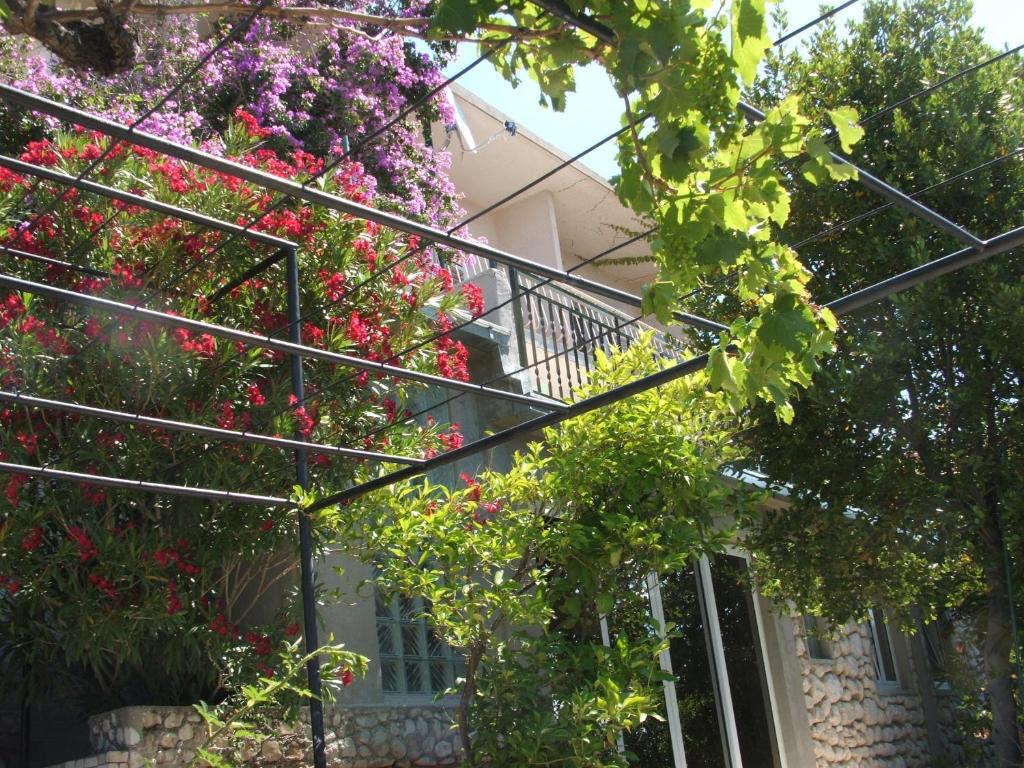 una casa con flores rosas en el balcón en Apartments Stari Pavle, en Brela