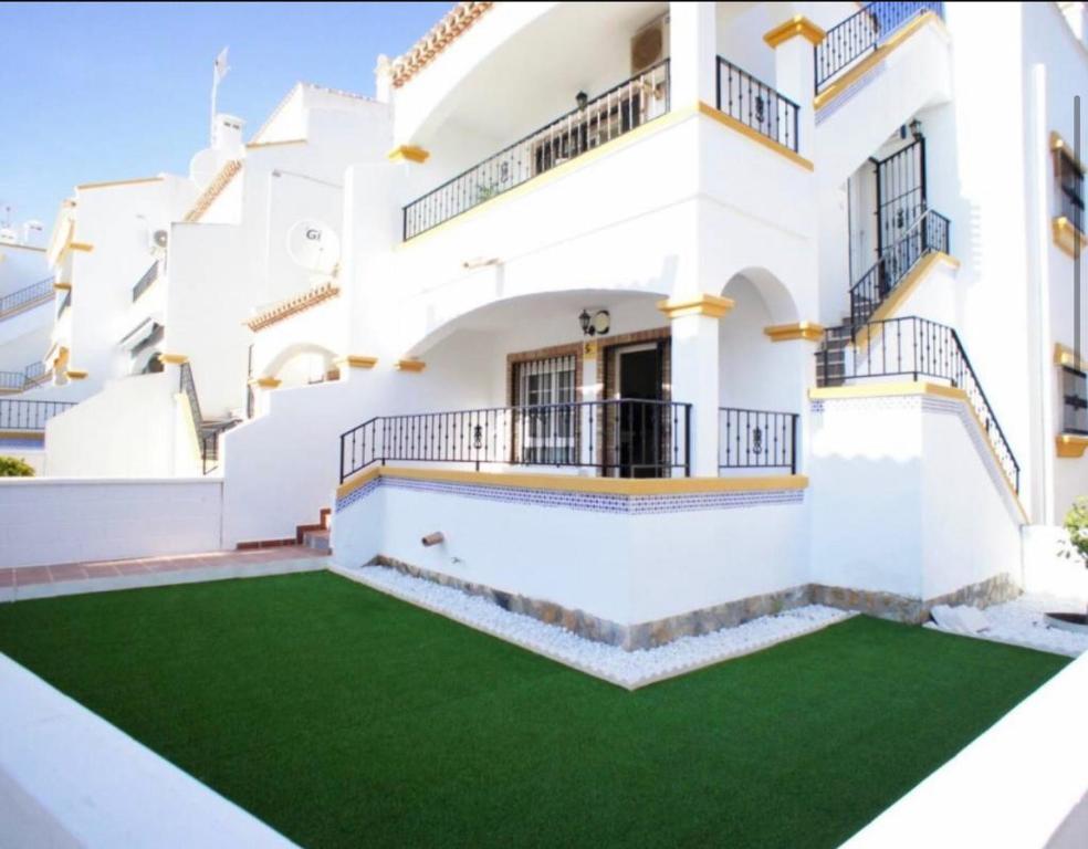 een huis met een groen gazon ervoor bij Bungalow Los Dolses in Orihuela