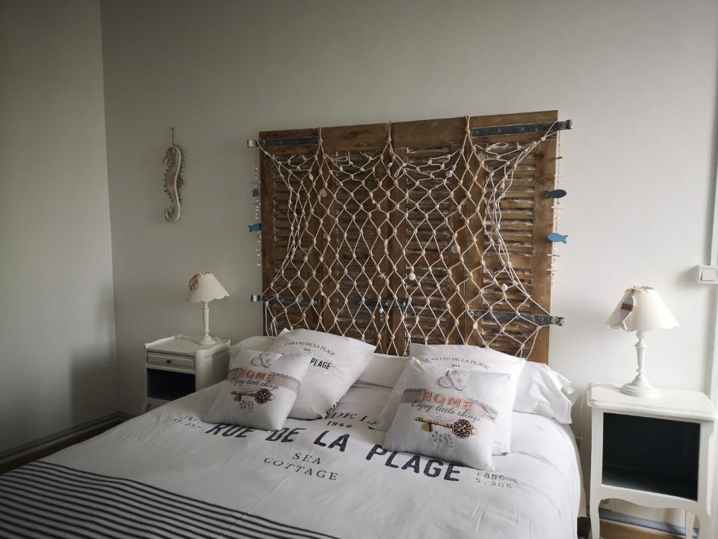 um quarto com uma cama com cabeceira e almofadas em Une affaire de famille em Le Portel