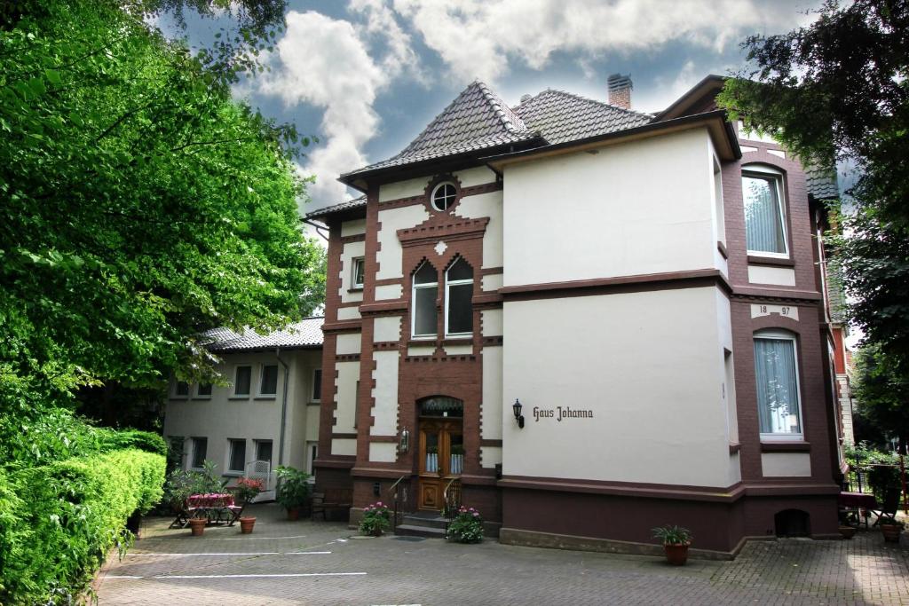dom z biało-brązowym budynkiem w obiekcie Hotel-Garni Haus Johanna w mieście Einbeck