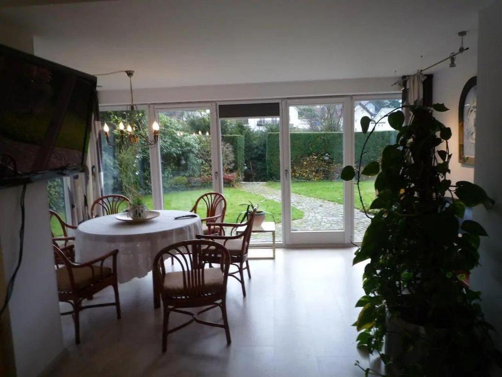 a dining room with a table and chairs and a plant at Appartement-Landhaus-Kruse in Meschede