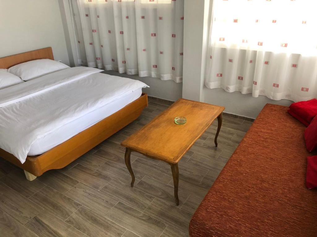 sypialnia z łóżkiem i drewnianym stołem w obiekcie Mala Vikendica w mieście Bezdan