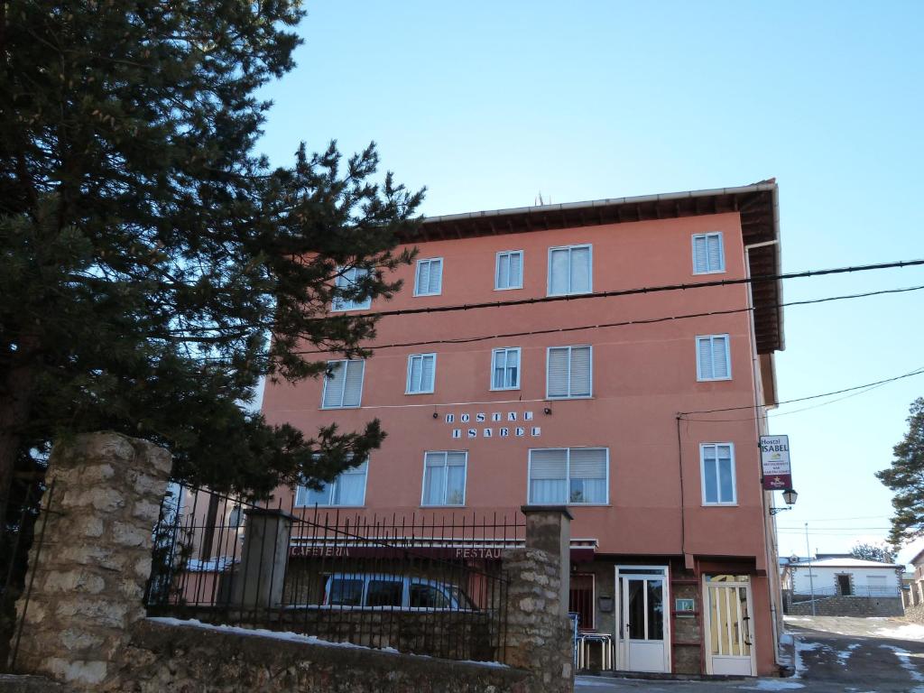 a red building with a sign on it at Hostal Isabel in Bronchales