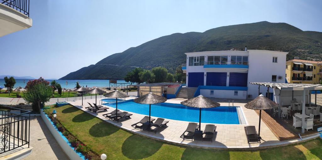 a resort with a swimming pool with chairs and umbrellas at Surf Hotel in Vasiliki